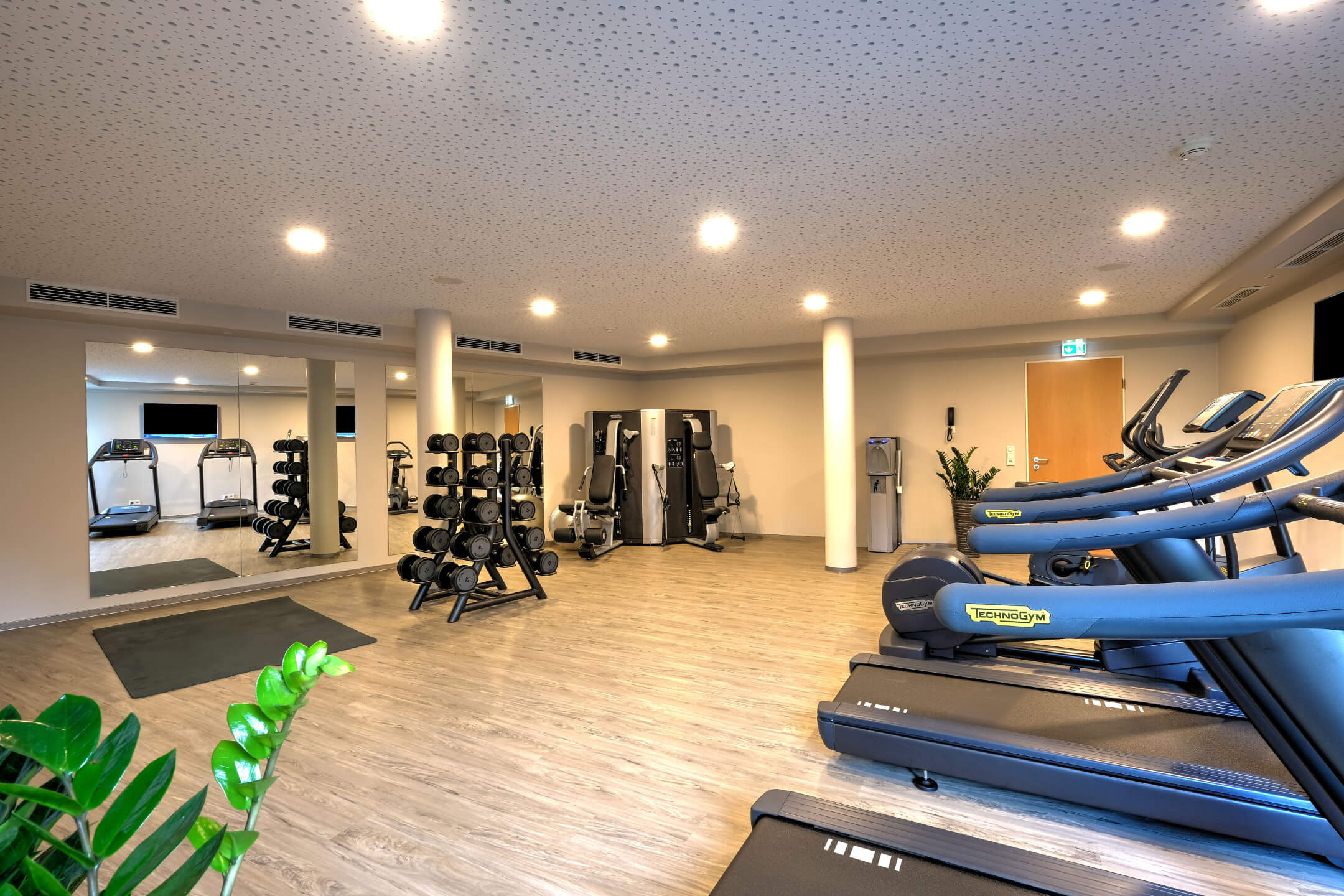 Fitnessraum im ATLANTIC Hotel Airport Bremen Heller Fitnessraum im ATLANTIC Hotel mit Laufbändern, Hanteln und Trainingsgeräten.
