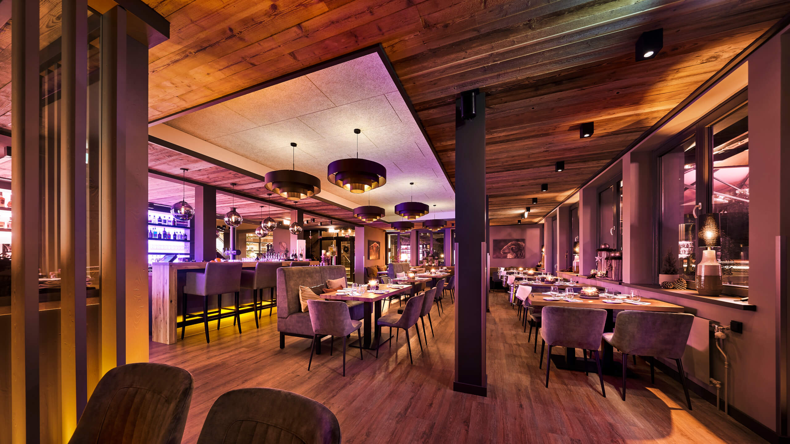 Restaurant Chalet im ATLANTIC Hotel Landgut Horn Bremen Gemütliches Hotelrestaurant mit warmem Holzinterieur, gedeckten Tischen und stimmungsvoller Beleuchtung.