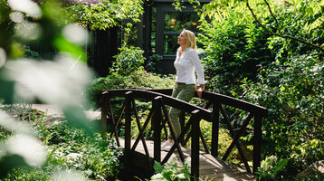 ATLANTIC Hotel Landgut Horn Entspannen im Garten Eine Frau genießt das schöne Wetter im Garten vom ATLANTIC Hotel Landgut Horn