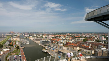 Aussichtsplattform ATLANTIC Hotel Sail City Blick von ATLANTIC Hotel Sail City auf Bremerhavens Hafen und Stadt bei klarem Himmel, mit Besuchern auf der Aussichtsplattform.