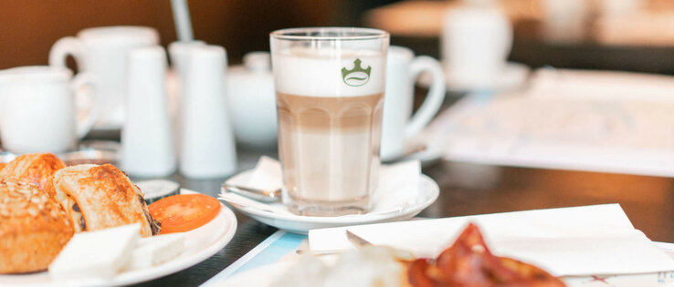 ATLANTIC Hotel Lübeck Frühstück Frühstückstisch im ATLANTIC Hotel Lübeck mit Kaffee, Gebäck und frischen Tomaten.