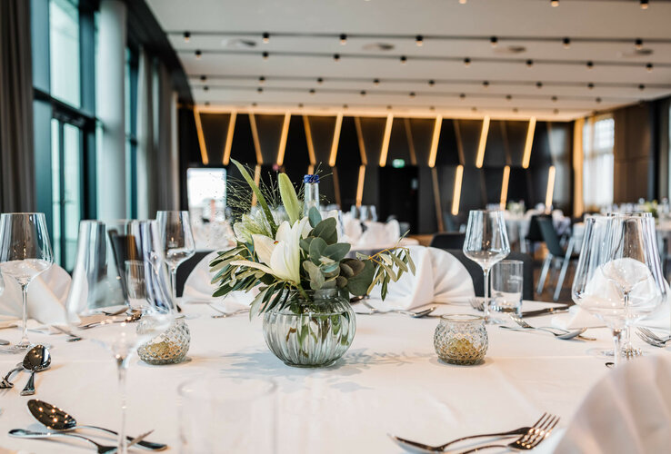 Engelsaal im ATLANTIC Hotel Münster Eleganter Bankettsaal mit gedecktem Tisch, Blumenarrangement und stilvoller Beleuchtung im ATLANTIC Hotel Münster.