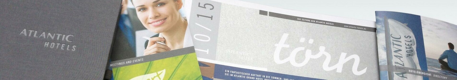 Verschiedene Broschüren und Magazine von Atlantic Hotels auf einem Tisch ausgebreitet.