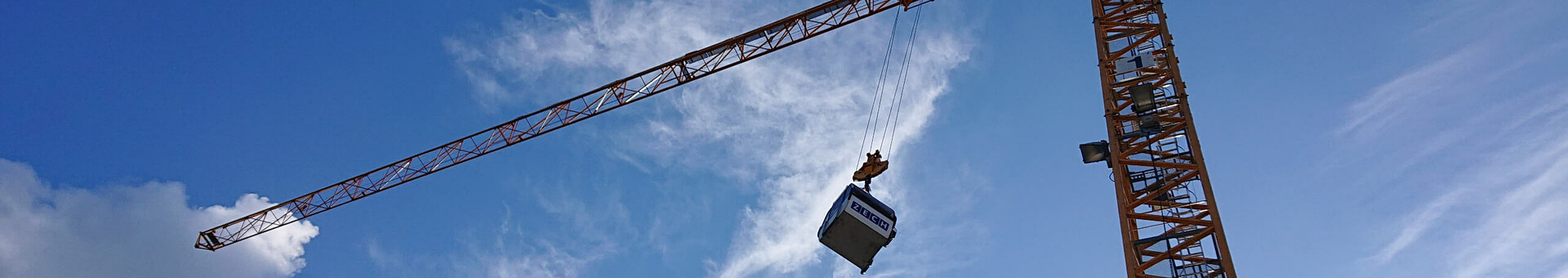 ATLANTIC Hotels lädt ein zum „Tag der Gondel“ in Münster Kran hebt Container vor blauem Himmel mit Wolken.