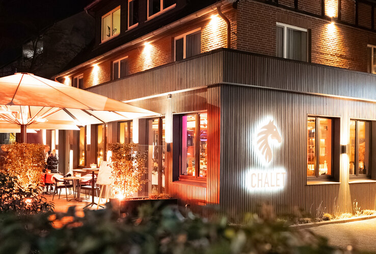 Das Restaurant CHALET stilvoll beleuchtet bei Nacht.