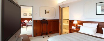 Bedroom with a bed and flatscreen TC in the Cutty Sark Suite of the ATLANTIC Hotel Wilhelmshaven 