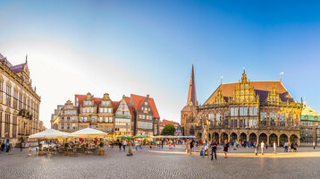 Marktplatz in Bremen im Sommer Historische Gebäude am Bremer Marktplatz bei Sonnenschein, Menschen flanieren auf dem Kopfsteinpflaster.