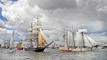Boote auf dem Wasser während der Kieler Woche Segelschiffe auf der Kieler Förde unter bewölktem Himmel, maritimes Flair.