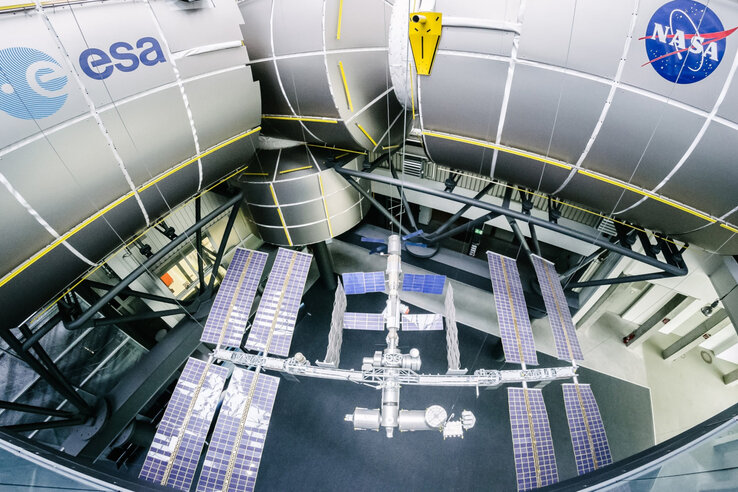 Modell ISS und Columbus Modul | Raumfahrt-Führung Bremen Modell der Internationalen Raumstation unter ESA- und NASA-Logos in einem Ausstellungsraum.