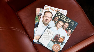 ATLANTIC Grand Hotel Bremen News Zeitschriften "Culinaire" auf einem braunen Ledersessel im ATLANTIC Grand Hotel Bremen.