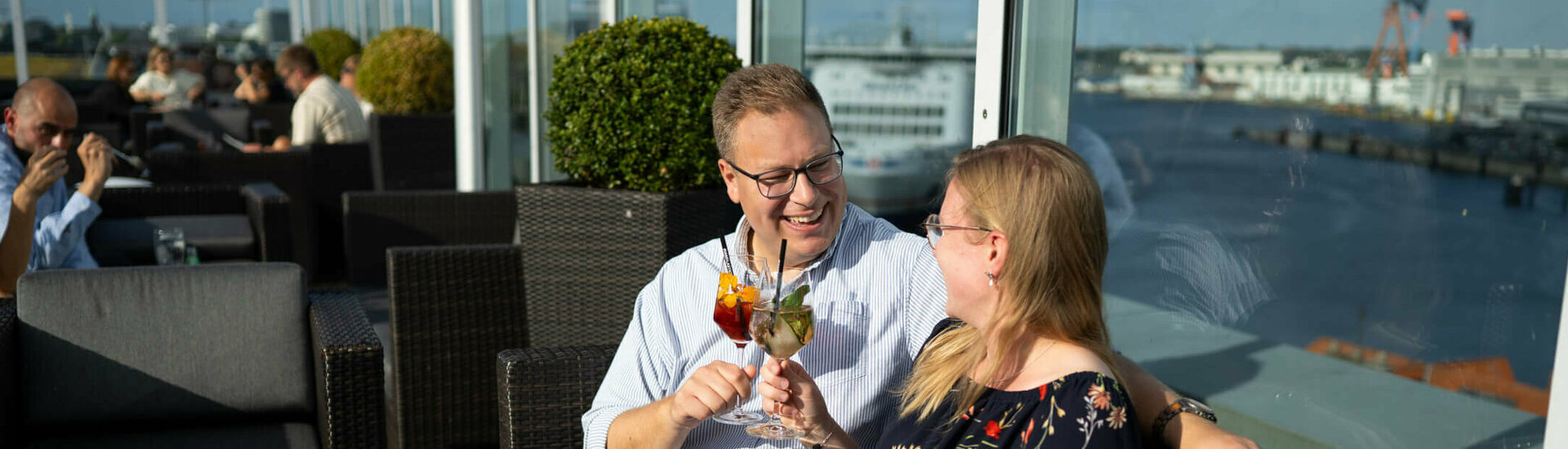 ATLANTIC Hotel Kiel Deck 8 Bar Anstoßen bei Sonne auf der Dachterrasse von der Bar Deck 8