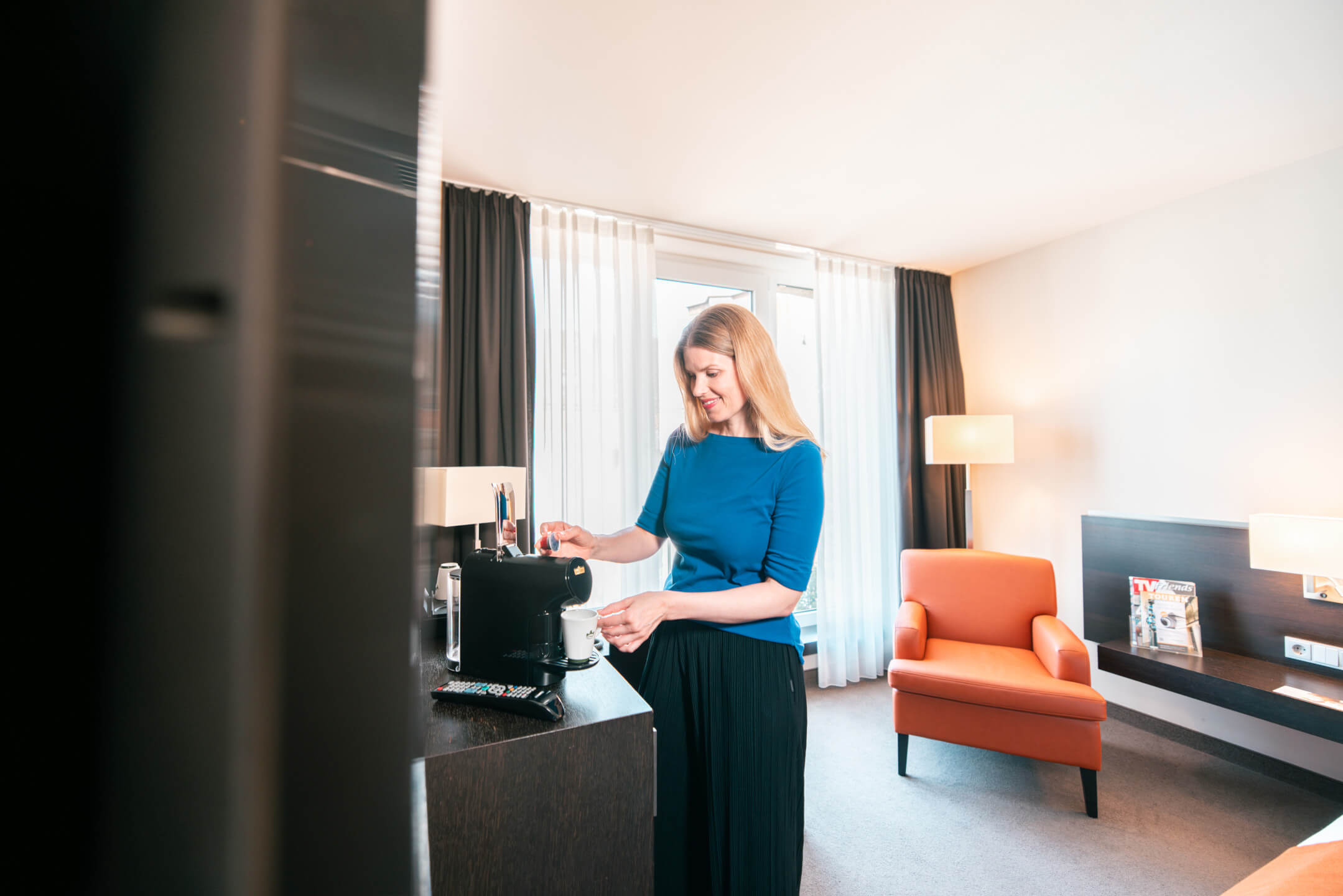 Kaffeezubereitung im ATLANTIC Hotel Lübeck Woman makes herself a coffee in the hotel room of the ATLANTIC Hotel Lübeck