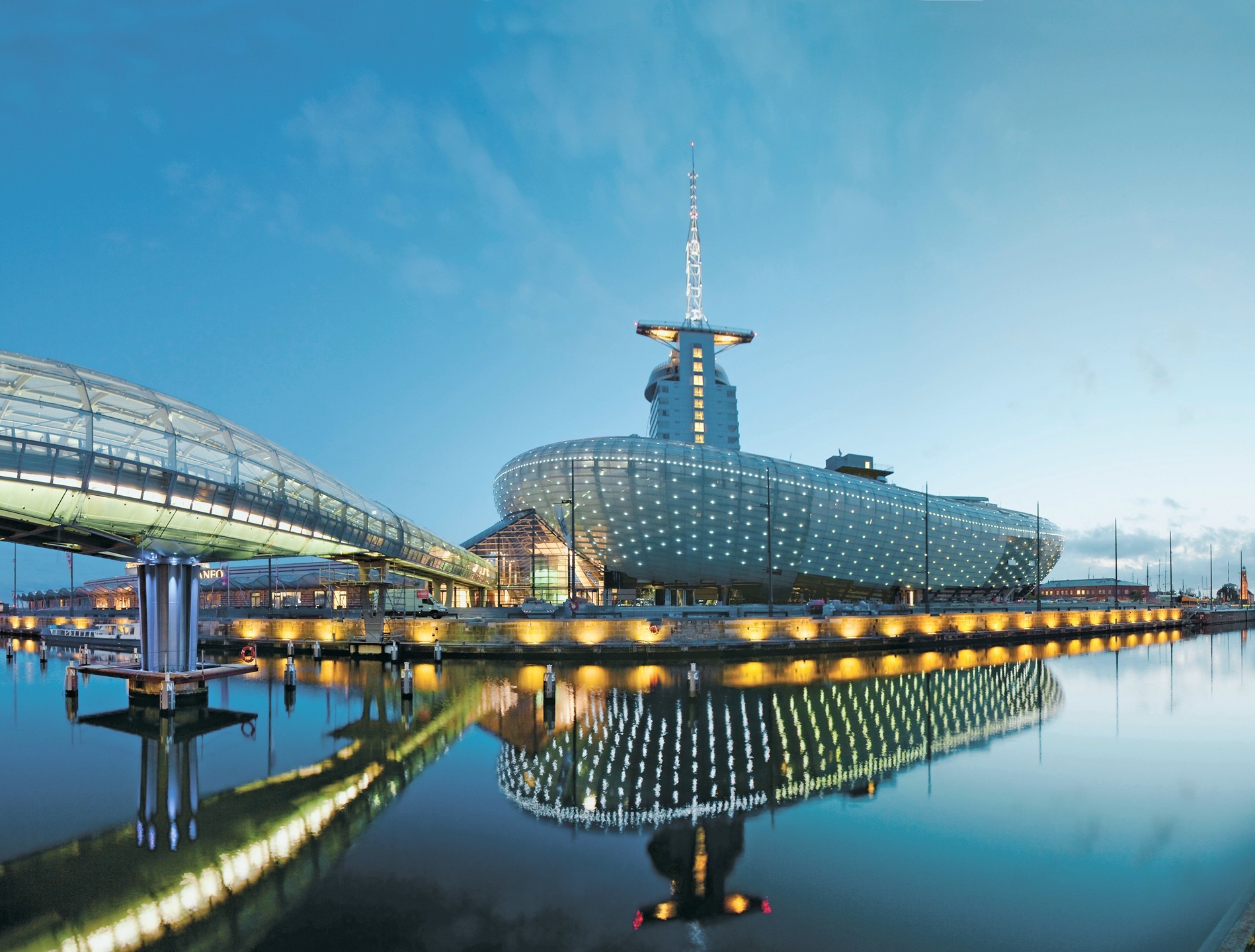 View on the Klimahaus Bremerhaven with its reflection in the water Futuristic building on the water with illuminated, glass transition and clear reflection in the calm water.