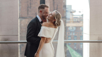 ATLANTIC Grand Hotel Bremen wedding celebration Bride and groom smiling at each other on a terrace of the ATLANTIC Grand Hotel Bremen, historic architecture in the background.