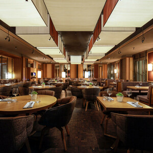 The LOUIS Grillroom - Restaurant München Elegantes Restaurant im LOUIS Hotel München mit stilvoll gedeckten Tischen und gemütlicher Beleuchtung.