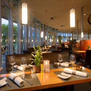 Restaurant CAMPUS im ATLANTIC Hotel Universum Bremen Modernes Hotelrestaurant mit elegant gedeckten Tischen, großen Fenstern und stimmungsvoller Beleuchtung im ATLANTIC Hotel Universum.