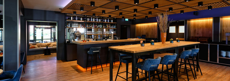 Stehtische mit Barhockern und die Bar im Restaurant CHALET