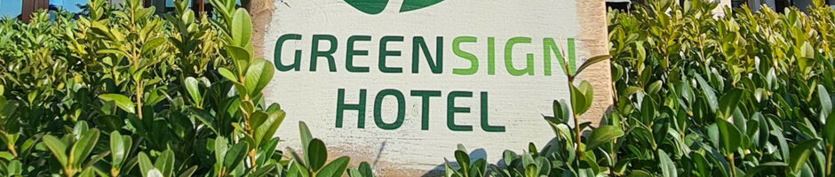 GreenSign Certificate | ATLANTIC Hotels Hotel sign "Greensign Hotel" surrounded by green shrubs.