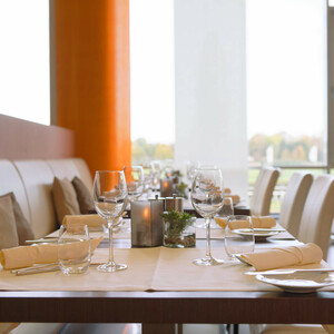 Restaurant Gottlieb im ATLANTIC Hotel Galopprennbahn Modernes Restaurant mit elegant gedeckten Tischen, weißen Stühlen und großen Fenstern im ATLANTIC Hotel Galopprennbahn.