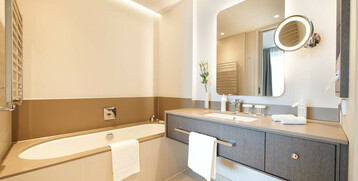 Bathroom Executive Suite in the ATLANTIC Grand Hotel Bremen Modern hotel bathroom with bathtub, large mirror, double washbasin and towel rail, elegant and bright.