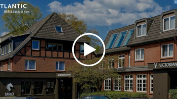 ATLANTIC Hotel Landgut Horn Bremen Brick facade of the ATLANTIC Hotel Landgut Horn Bremen with half-timbered details, surrounded by trees under a blue sky.