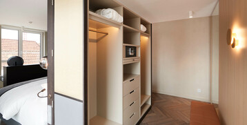 Wardrobe of the Grand Suite at the Atlantic Grand Hotel Bremen Modern hotel room with open closet, safe, bed and large windows at the ATLANTIC Grand Hotel Bremen.