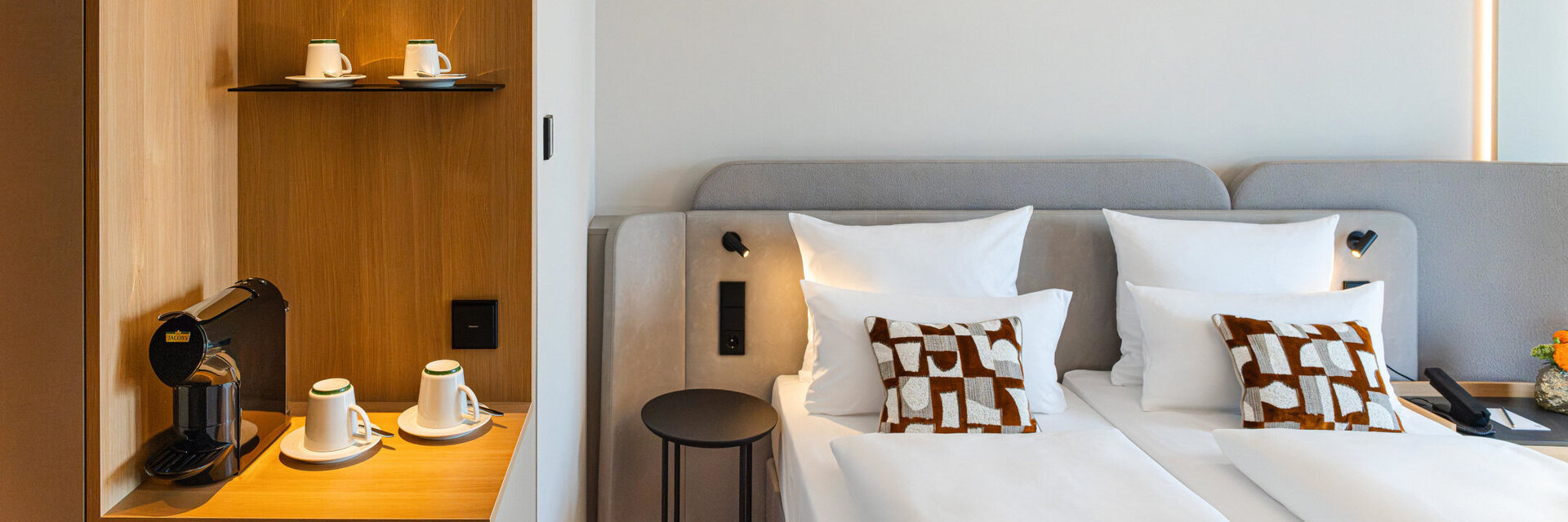 Bett im Superior Doppelzimmer und die Kaffeestation mit warmen Holztönen.