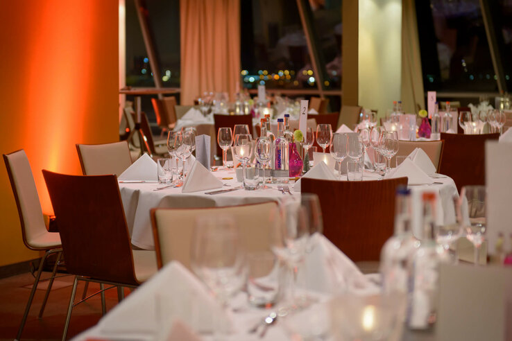 Conference room of the ATLANTIC Hotel SAIL City Elegant hotel restaurant with white-clothed tables, glasses and soft lighting at the ATLANTIC Hotel Sail City.