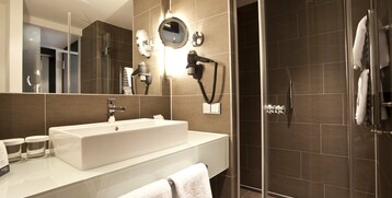 Bathrrom of the Superior Room in the ATLANTIC Grand Hotel in Bremen Modern bathroom at the ATLANTIC Grand Hotel Bremen with washbasin, mirror, hairdryer and shower.