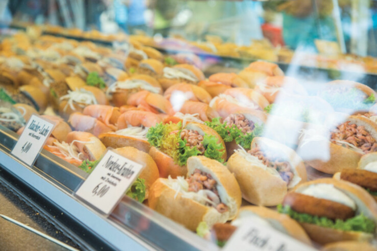 Seaside City Festival Bremerhaven Display of various sandwiches, including salmon and crab, behind a pane of glass in a delicatessen.