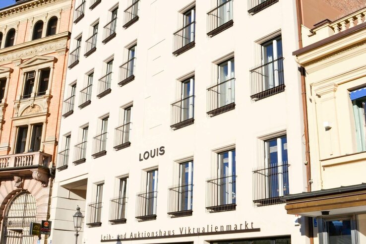 LOUIS Hotel in München Fassade des LOUIS Hotels in München mit mehreren Fenstern und einem historischen Nachbargebäude.