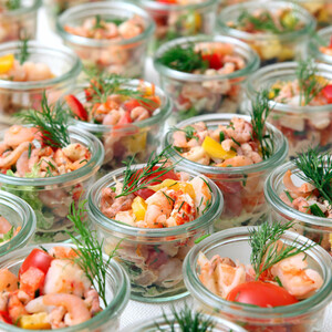 Buffets and finger food by ATLANTIC Hotels Several glasses of shrimp salad, decorated with dill and colorful vegetables.