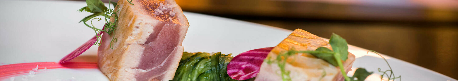 Dishes for events at ATLANTIC Hotel Lübeck Gourmet dish with tender fish, decorated with beet slices and herbs on an elegant white plate.