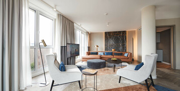 Exquisite lounge furniture in the living area of the Grand Suite at the Atlantic Grand Hotel Bremen Elegant hotel room with large windows, modern furniture and stylish decor at the ATLANTIC Grand Hotel Bremen.