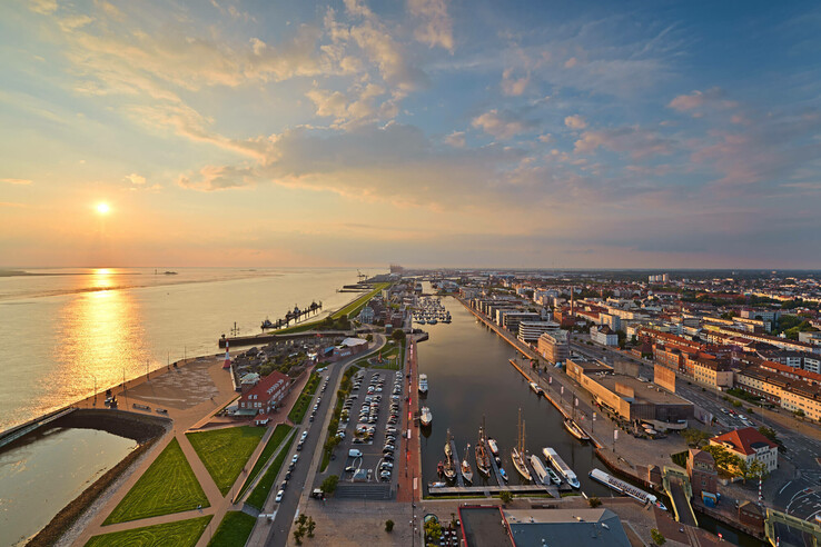 View over the new harbour in Bremerhaven View of Bremerhaven from the ATLANTIC Hotel Sail City at sunset, with harbor, river and city panorama.