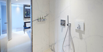 Bathroom of the Grand Suite at the Atlantic Grand Hotel Bremen Modern hotel bathroom with rain shower, marble walls and washbasin at the ATLANTIC Grand Hotel Bremen.