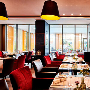 Restaurant alto im ATLANTIC Grand Hotel Bremen Modernes Restaurant im ATLANTIC Grand Hotel Bremen mit eleganten roten Stühlen, gedeckten Tischen und großen Fenstern.