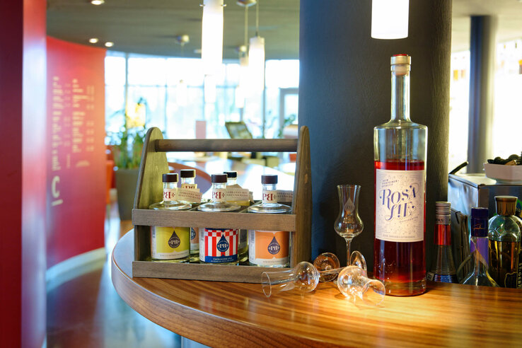 Eat in the ATLANTIC Hotel Bremen Universum Selection of drinks with spirits and glasses on a wooden counter in the ATLANTIC Hotel Universum Bremen.