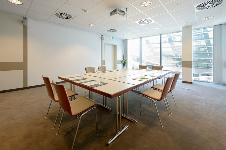Conference room of the ATLANTIC Hotel SAIL City Modern conference room with large table, chairs and large windows in the ATLANTIC Hotel Sail City Bremerhaven.