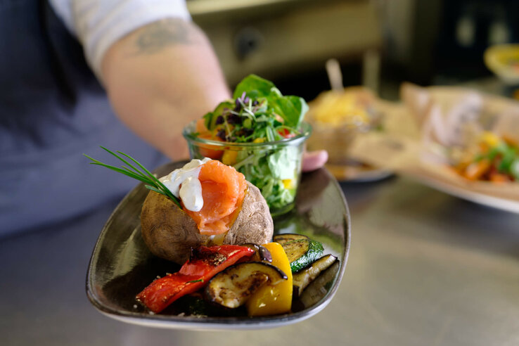Restaurant Campus in the ATLANTIC Hotel Bremen Universum Gourmet dish with baked potato, salmon, vegetables and salad at the ATLANTIC Hotel Universum Bremen.