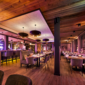 Restaurant Chalet im ATLANTIC Hotel Landgut Horn Bremen Gemütliches Hotelrestaurant mit warmem Holzinterieur, gedeckten Tischen und stimmungsvoller Beleuchtung.