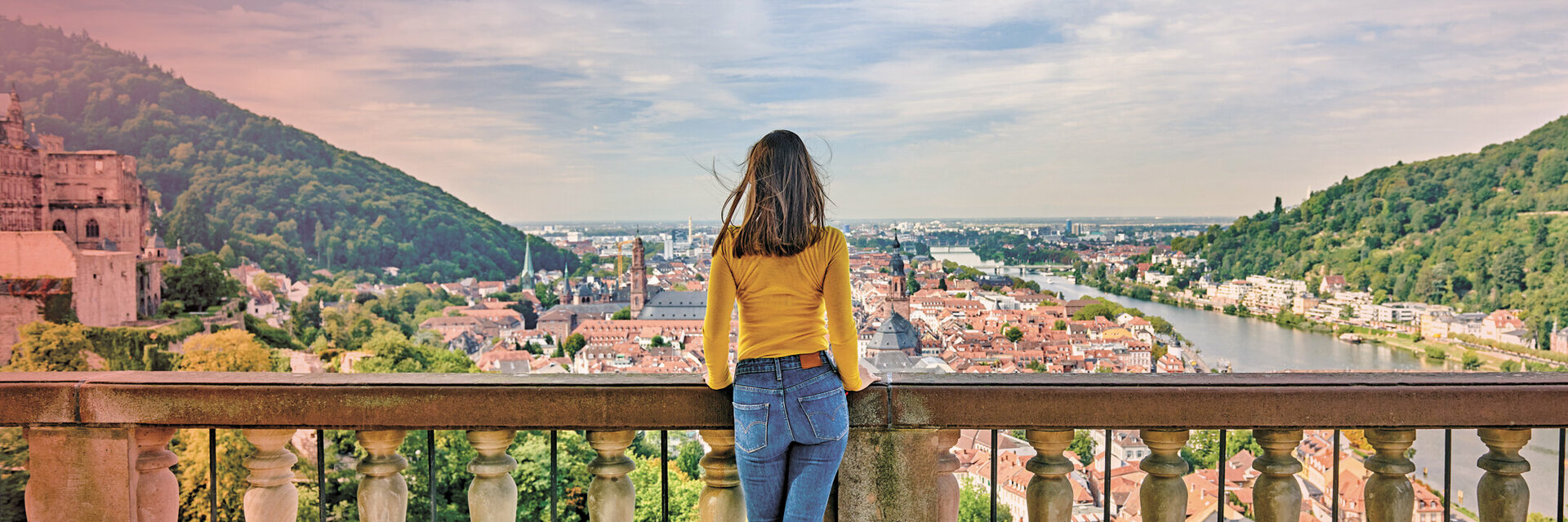 ATLANTIC Hotels Freizeitbroschüre Eine Frau steht an einem Aussichtspunkt mit Blick über Heidelberg