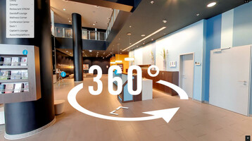 ATLANTIC Hotels in 360° Moderne Hotellobby mit hohen Decken, schwarzen Säulen, Infotafeln und Empfangsbereich in stilvollem Design.