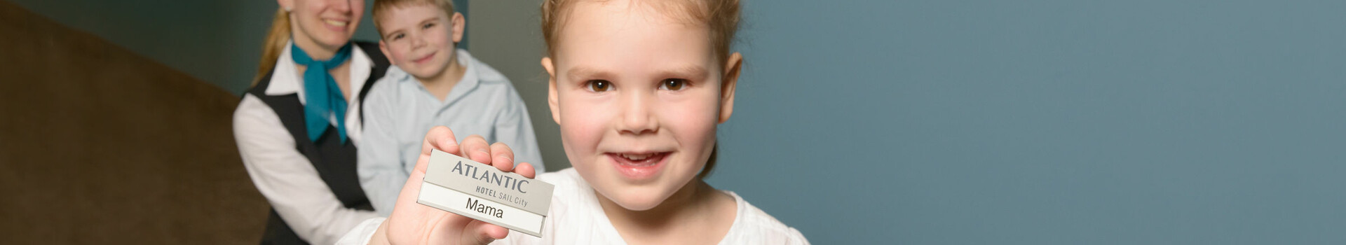 ATLANTIC Hotel SAIL City – the family-friendly workplace Little girl wearing a night gown is holding up a sign saying "Mama" in the ATLANTIC Hotel SAIL City – The family-friendly workplace