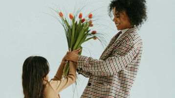 Muttertag bei den ATLANTIC Hotels Kind schenkt Mutter Blumen