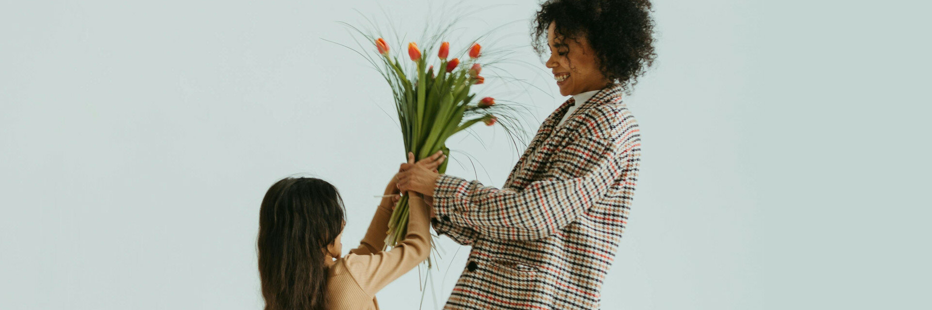 Muttertag bei den ATLANTIC Hotels Kind schenkt Mutter Blumen