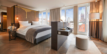 Sleeping area in the Grand Suite at the ATLANTIC Grand Hotel Bremen Modern hotel room at the ATLANTIC Grand Hotel Bremen with double bed, stylish furnishings and a view of the city.